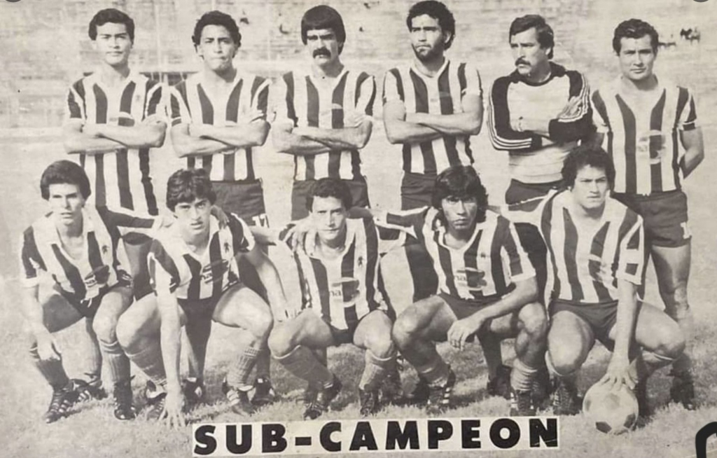 Tip Nac, Subcampeón de Copa 1985
Tip Nac, Subcampeón de Copa 1985, el campeón fue Juventud Retalteca: Otto González, Jorge Salazar, Venancio Zelaya, Jorge González, Juan Pablo Illescas, Silvio Romeo Aquino. Abajo: Mario Semilla Orellana, Armando Plaja, Boris Ortiz, Salvador el Tractor Rodríguez, Roberto Maza
Tipografía Nacional Subcampeón de Copa 1985: el regreso del decano
En 1985, Tipografía Nacional logró alcanzar la final de la Copa de Guatemala, enfrentando a Juventud Retalteca en un emocionante encuentro. Aunque no lograron alzarse con el título, el equipo demostró su calidad y compromiso en el campo. Jugadores como Otto González, Jorge Salazar y Venancio Zelaya fueron fundamen